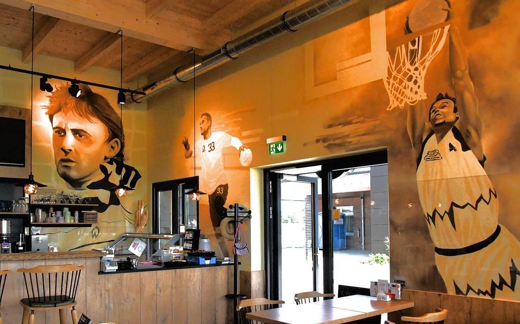 Kunstvoll bemalt sind die Wände in der neuen Sportsbar mit Sportgrößen aus Breme...