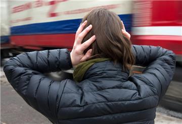  Eine Frau hält sich am 11.01.2013 in Hamburg vor einem nahenden Lastwagen die Ohren zu. 