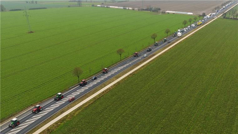 Bauernproteste reißen nicht ab Landwirte fahren mit ihren Traktoren im Schritttempo über eine Bundesstraße.