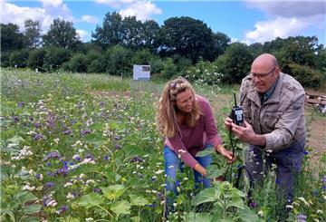 Landwirtin Linda Hühnken und Professor Jelle Bijma kontrollieren die Messgeräte, die auf den Versuchsflächen verteilt sind.