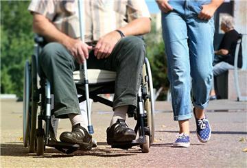 Person im Rollstuhl mit Pflegerin