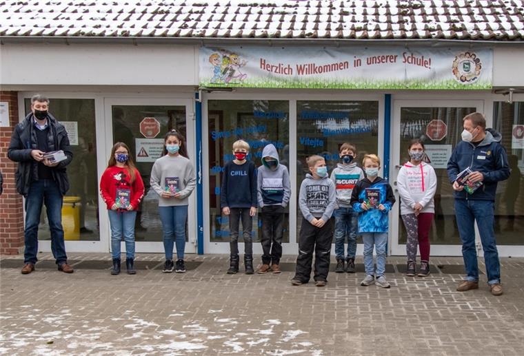 Lars Behrje (links) und Marc Petrikowski (rechts) vom Hagener Rotary-Club verteilten Bücher an die Loxstedter Grundschüler.