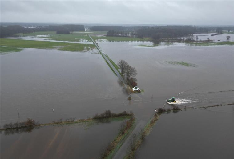 Das Hochwasser von oben: So schlimm ist die Lage im Norden (Bilder) Lathen: Ein Traktor fährt über eine überflutete Straße im Hochwassergebiet.