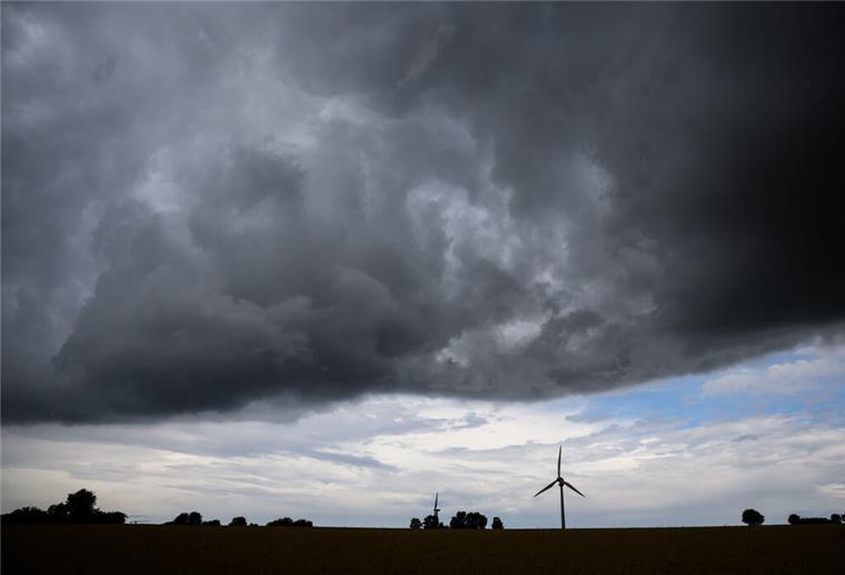 Vermiesen uns Schauer und Gewitter die freien Pfingsttage? Eine Gewitterfront zieht über ein Windrad in der südlichen Region Hannover hinweg.