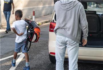 Ein Taxifahrer (r) hat gerade mit seinem Fahrzeug einen Grundschüler aus einem weiter entfernten Stadtteil vor die Schule gefahren. 