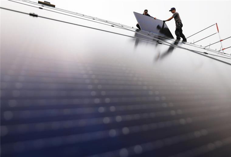 Nordenham: Ausbau der Fotovoltaik hinkt hinterher Handwerker montieren auf dem Dach eines Wohnhauses Solarmodule