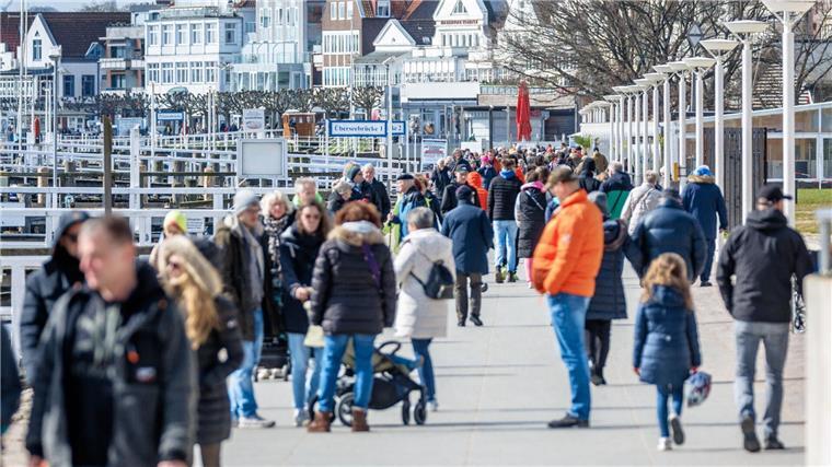 Leute sind am Samstagvormittag auf der Promenade von Travemünde unterwegs.