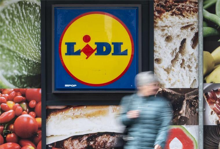 Schon ab August! Lidl ändert Pfand-System in ganz Deutschland grundlegend Eine Passantin geht an der Außenwerbung einer Lidl-Filiale vorbei.