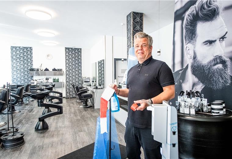 Lokale Friseurstudios bereiten sich mit Hygienemaßnahmen auf ihre Kundschaft für die Wiederöffnung ihrer Läden ab 4. Mai vor. Andre Albers, Inhaber des Frisörsalons "Hauptsache" in der Bremerhavener Georgstraße, bereitet seinen Salon mit Absperrband, Desinfektionsmittelspender und Bodenleitlinien auf den Kundenansturm vor. Foto: Hartmann