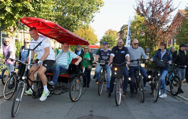 Los geht’s! Mit einer gut gelaunten Begleitschar per Fahrrad startet HSV-Rikscha-Pedalist Michael Butt mit seinem Werder-Wettkontrahenten Peter Meyer im Fond die denkwürdige Tour ab Zeven zum Bundesligaspiel nach Bremen. 