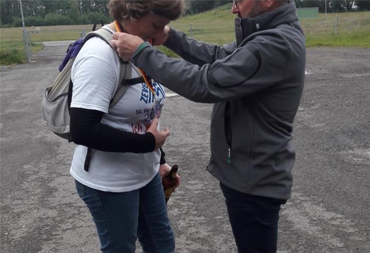 Lothar Maack hängt seiner Ehefrau Angelique am vierten Marsch-Abend eine Medaille um, die er eigens in der Pokaldiele Zeven hat anfertigen lassen.