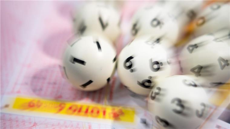 Glückspilz aus gewinnt Millionensumme bei Eurojackpot Lotto-Kugeln liegen auf einem Lottoschein.