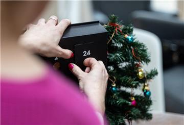 SYMBOLBILD - 14.11.2024, Berlin: Eine Frau öffnet die 24. Tür eines Adventskalenders für Erwachsene. (zu dpa: «Adventskalender ohne Schokolade: Drei Trends für Erwachsene») Foto: Hannes P. Albert/dpa +++ dpa-Bildfunk ++