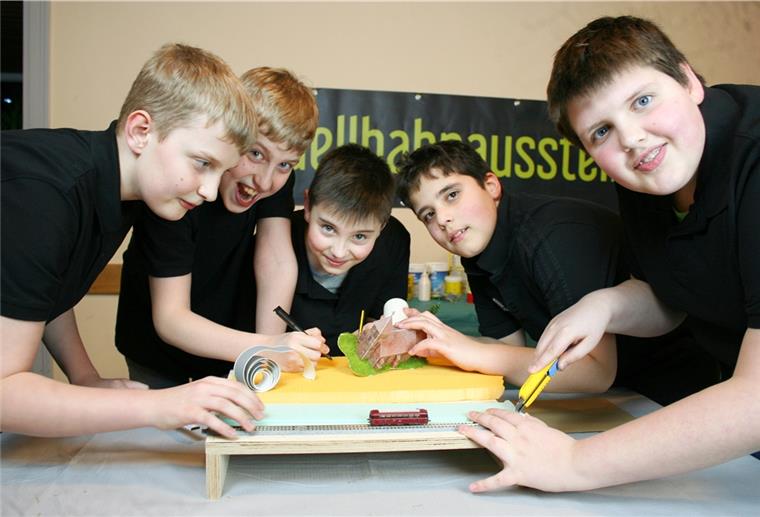 Modellbahn: Eine Zugverbindung zwischen Surheide und Schiffdorf Malte, Ben, Franz, Jimmy und Finn (von links) arbeiten an den letzten Details für den Fahrtag. Jimmy hält die Schiffdorfer Kirche in der Hand.