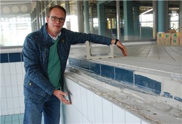 Manuel Kuhn und die maroden Beckenköpfe in der Moor-Therme: Die Hände des Badleiters verdeutlichen, in welchem Bereich die Ränder erneuert werden müssen.