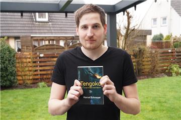 Marcel Schmeyer (24) mit seinem Buch „Tengoku – Der Junge mit den roten Haaren“.