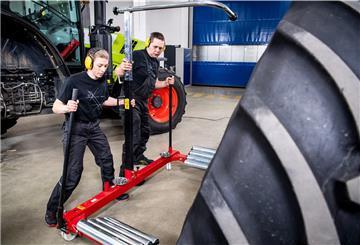 Mariam Suhk (l.) und Menko Lottmann wechseln das Hinterrad von einem Traktor. Mit 3 Minuten und 16 Sekunden haben die beiden Schrauber einen neuen Weltrekord aufgestellt.