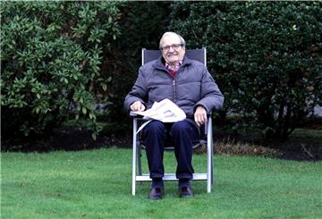 Ein Mann sitzt im Garten in einem Stuhl