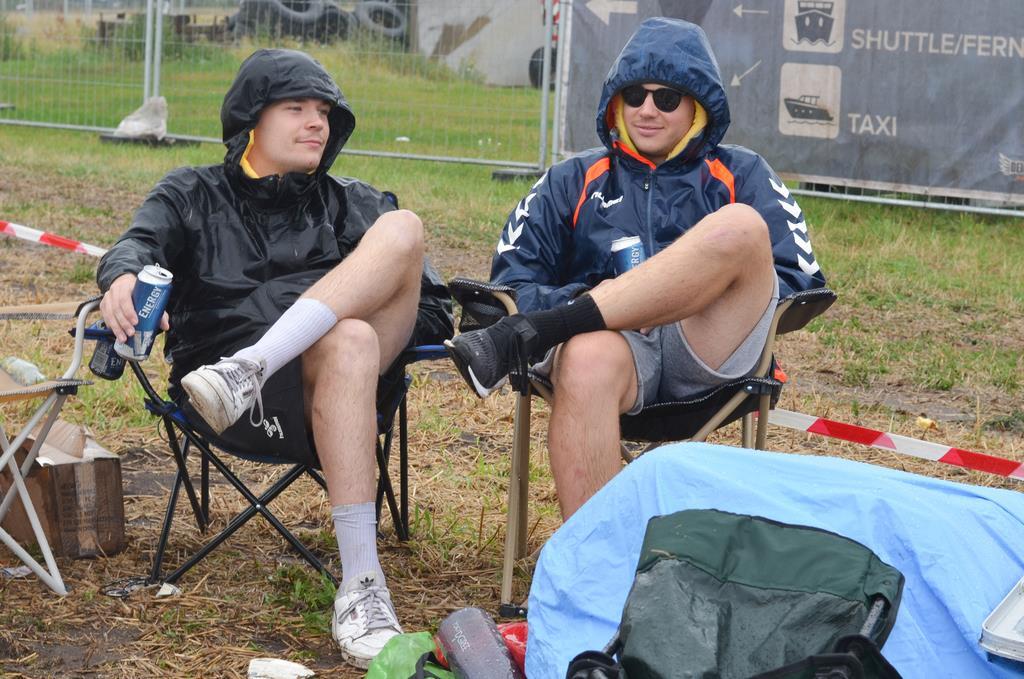 Marius (links) und Philipp aus Münster warten im strömenden Regen auf ihre Freun...