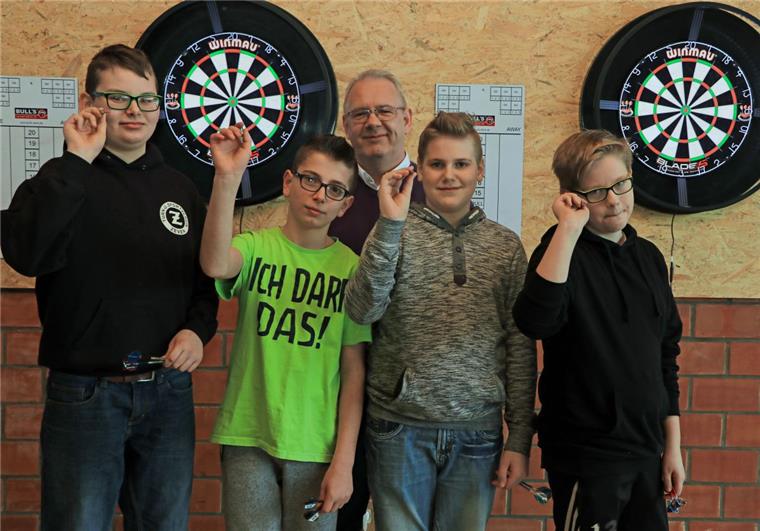 Neues Angebot im Ganztagsbereich: Schüler der IGS Zeven spielen Darts Mark Borkenhagen, Abteilungsleiter für Darts des TuS Zeven (Mitte), hat bei Milan Eberhardt, Luca Haase, Raul Dordea, Felix Oetjen (von links) die Faszination für den Präzisionssport schon in den ersten drei Wochen des neuen Ganztagsangebotes geweckt.