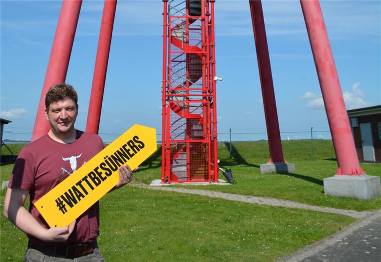 Große Kampagne für die Küste Marketingexperte Oliver Knagge weist mit dem „Watt Besünners“-Schild auf das Leuchtfeuer. Foto: Timmermann