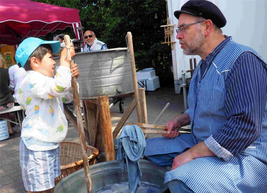 Martin Dücker zeigt dem Knirps wie früher Wäsche gewaschen wurde. Foto Stehn