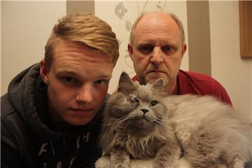 Marvin (links) und Volker Röper mit ihrem geliebten Kater Balou. Unbekannte haben in Lunestedt mit einem Luftgewehr auf das Tier geschossen und es am Kopf schwer verletzt.   