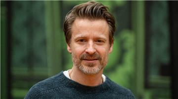Max von Pufendorf, Schauspieler, steht vor einer Theaterkulisse vom Stück „Cluedo“ auf der Probebühne der Komödie am Kurfürstendamm im Theater am Potsdamer Platz.