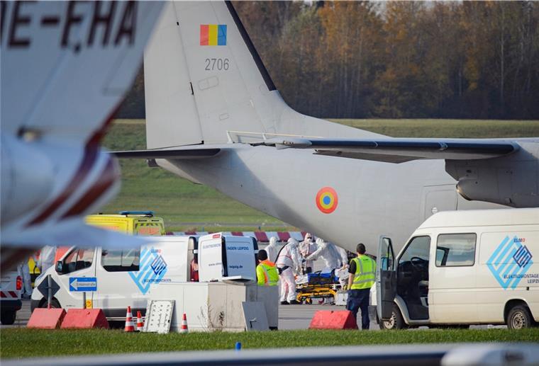 Medizinisches Personal in Schutzanzügen schiebt einen Corona-Intensivpatienten auf einem Krankenbett aus dem Laderaum einer C-27 - das kann auch in Deutschland bald Realität werden.