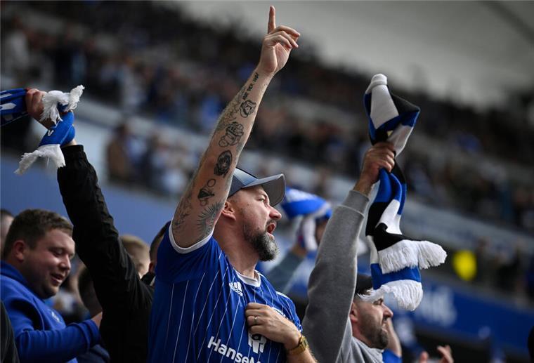Kreischalarm und Fan-Wahnsinn: Was Fans wirklich antreibt 26.10.2024, Hamburg: Fußball: Bundesliga, 8. Spieltag, FC St. Pauli - VfL Wolfsburg, im Millerntor-Stadion Ein junger St. Pauli Fan hält eine Regenbogenflagge auf der Tribüne hoch. St. Pauli Fans protestieren mit Plakaten und Regenbogenflaggen nach den homophoben Aussagen des Wolfsburger Stürmers Kevin Behrens. Foto: Marcus Brandt/dpa - WICHTIGER HINWEIS: Gemäß den Vorgaben der DFL Deutsche Fußball Liga bzw. des DFB Deutscher Fußball-Bund ist es untersagt, in dem Stadion und/oder vom Spiel angef