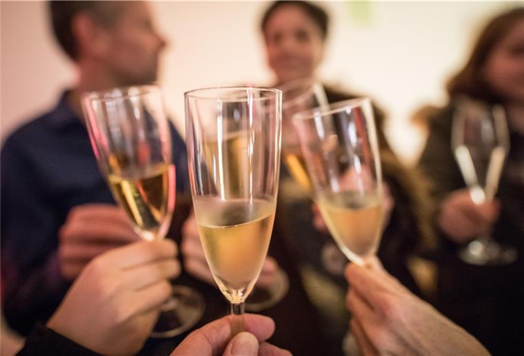 Silvesterpartys in Bremerhaven fallen diesmal kleiner aus Personen stoßen mit Sekt an.