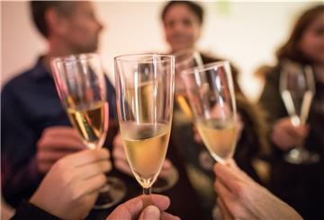 Personen stoßen mit Sekt an.