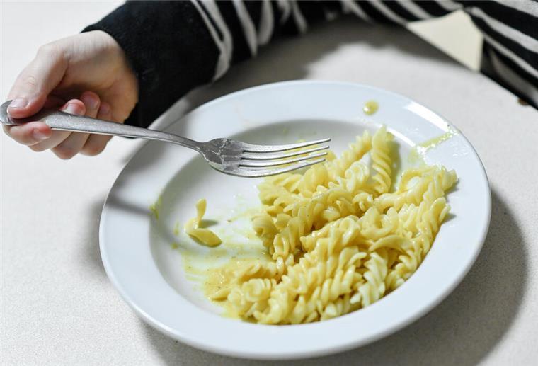 Kinder in Bremen und Niedersachsen besonders von Armut bedroht Ein Kind isst Nudeln von einem Teller.