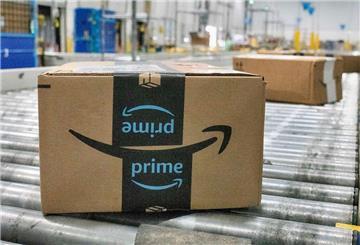 Mehrere Amazon-Pakete liegen auf einem Fließband. Amazon investiert kräftig und schafft neue Jobs in Deutschland. 