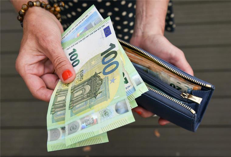 Millionen Bürger betroffen: Merz-Regierung plant deutliche Änderung beim Netto-Lohn Eine Frau hält eine mit mehreren Geldscheinen gefüllte Geldbörse in einer Hand, darunter Hundert-, Fünfzig- und Zwanzig-Euro-Scheine, und einige Geldscheine in der anderen Hand. Ein Plan der Merz-Regierung soll dafür sorgen, dass am Ende mehr Netto-Lohn bleibt.