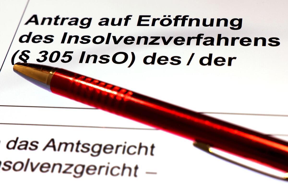 Insolvenzen auf Rekordniveau? Das droht Unternehmen jetzt Ein Kugelschreiber liegt auf dem Formular für einen Insolvenzantrag.