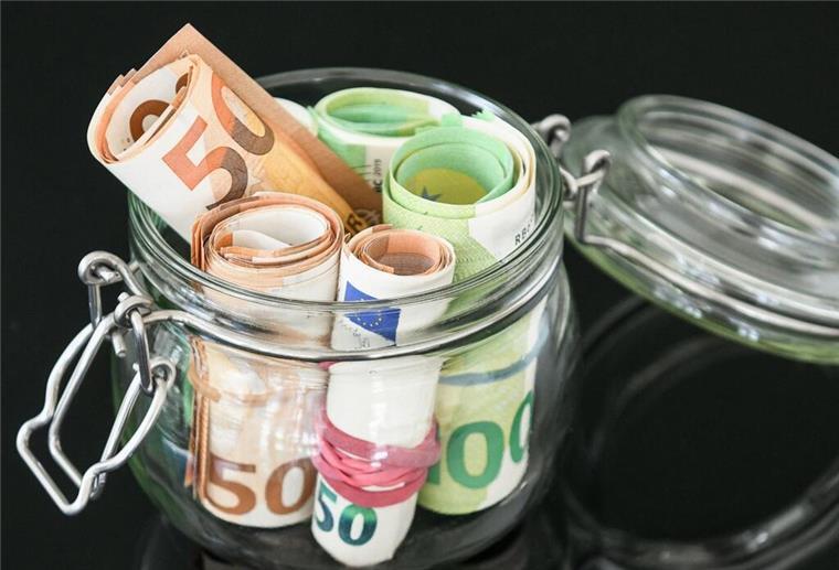Ein Glas mit Geldscheinen steht auf einem Tisch. Eltern mit älteren Kindern dürfen sich freuen: Die neue Mütterrente zahlt jetzt deutlich mehr.