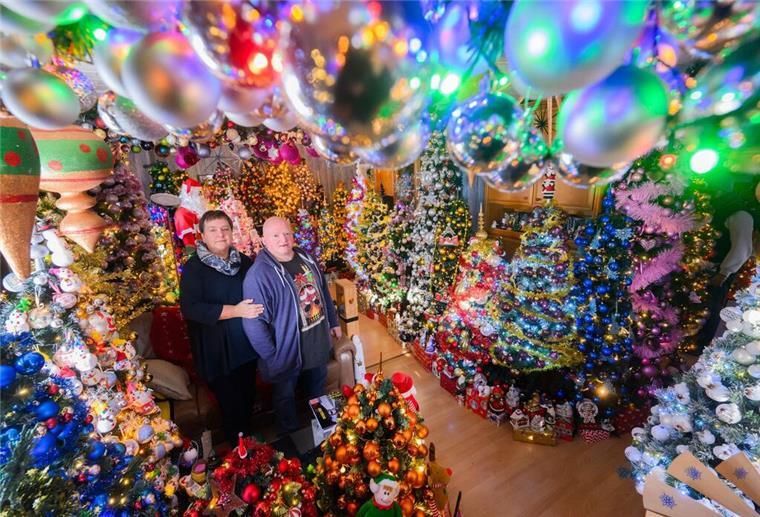 Rekord: Paar stellt 555 Weihnachtsbäume zuhause auf Mehr Weihnachten geht kaum: Susanne und Thomas Jeromin stehen inmitten von Weihnachtsbäumen im Wohnzimmer ihres Hauses.