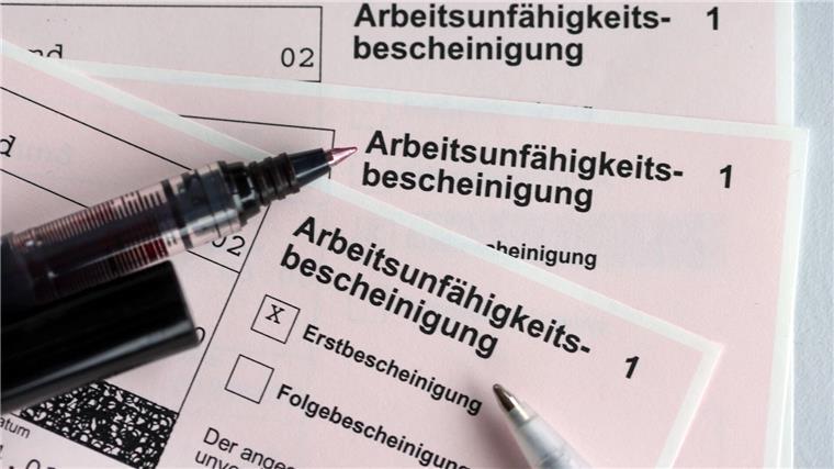 Handel: Geringerer Krankenstand und weniger Fluktuation Mehrere Arbeitsunfähigkeitsbescheinigungen liegen auf einem Tisch.