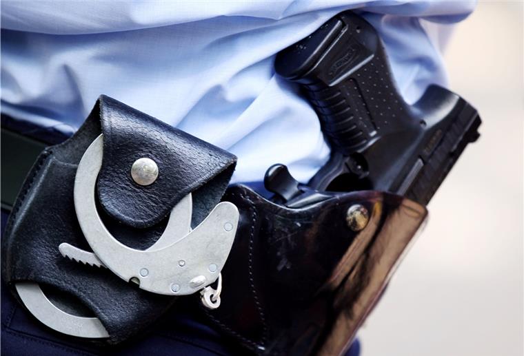 Der Gürtel einer Polizistin mit Handschellen und Pistole.  