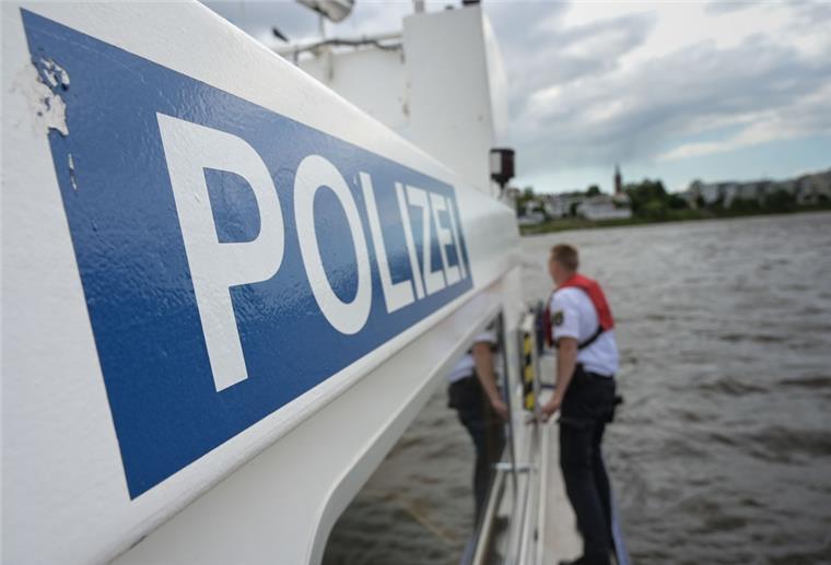 Bremerhaven: Schwimmer in der Weser verursacht Einsatz Ein Mann steht auf einem Boot mit dem Schriftzug Polizei.