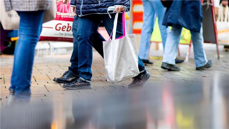 Geöffnete Geschäfte an Palmsonntag Menschen gehen am verkaufsoffenen Sonntag mit Einkaufstaschen durch die Fußgängerzone der Innenstadt.