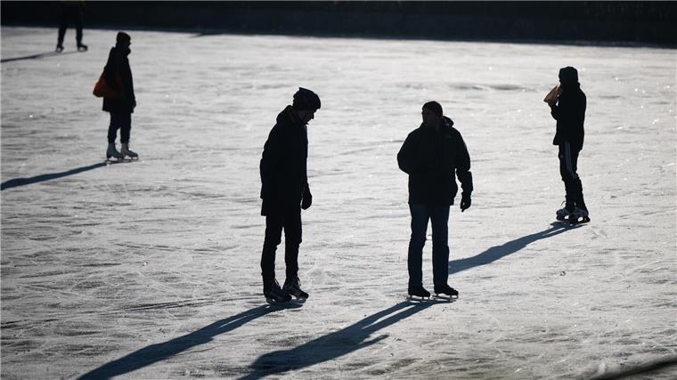 Eisfeld in Bremen für Schlittschuhbegeisterte geöffnet Menschen laufen auf auf einem zugefrorenen Stadtteich, Schlittschuh.