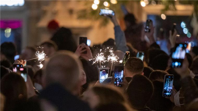 Silvester-Datenverbrauch im Handynetz auf Rekordhoch Menschen machen Fotos mit ihren Smartphones, während sie den Jahreswechsel feiern.