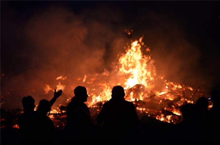 Osterfeuer: Waldbrandgefahr in Niedersachsen Menschen stehen am an einem Osterfeuer. Angesichts der hohen Waldbrandgefahr hat der Beauftragte des Landes zu besonderer Vorsicht bei den traditionellen Osterfeuern gemahnt.