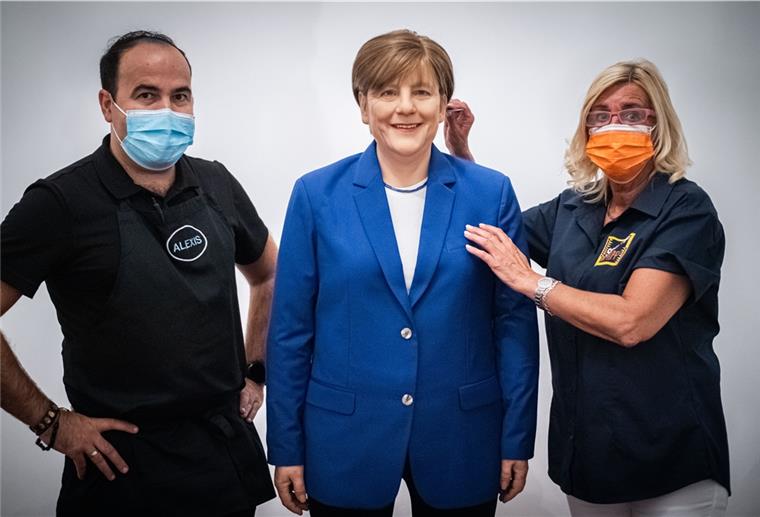Bremerhavener Gastronom hat eine Merkel-Wachsfigur Zwei Personen neben einer Wachsfigur der Bundeskanzlerin.