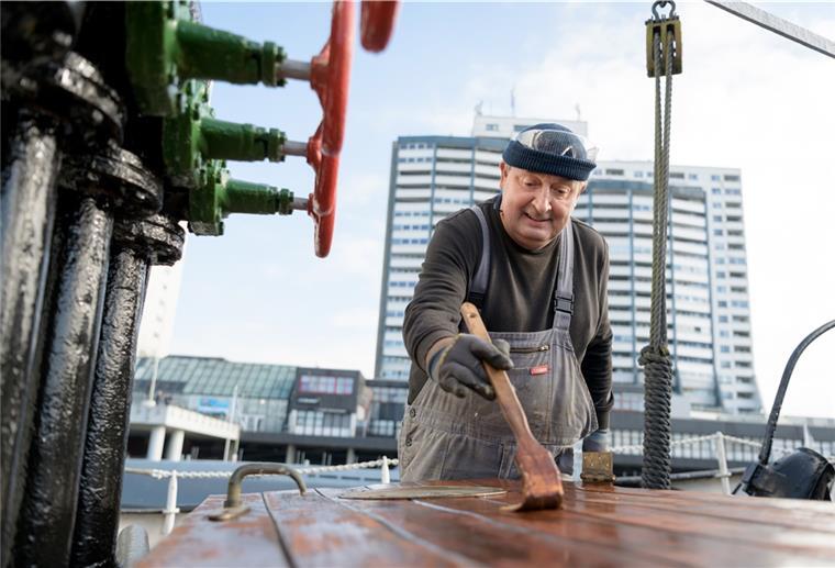 Arbeitslose reparieren Museumsflotte Mann mit Pinsel in der Hand.