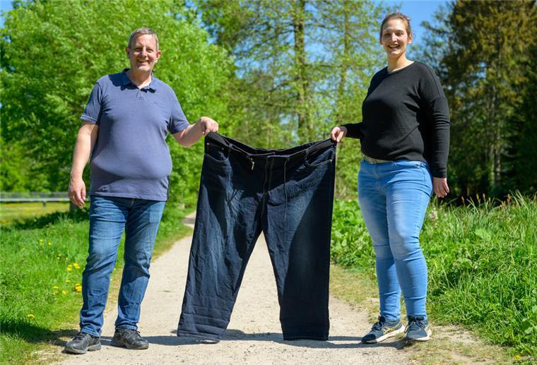 Michael Wirtz (l) und Meike Preußner halten eine Hose in Größe 60 in den Händen. Beide engagieren sich in der Adipositas-Selbsthilfe und haben in der Vergangenheit rund 160 Kilogramm auf die Waage gebracht.
