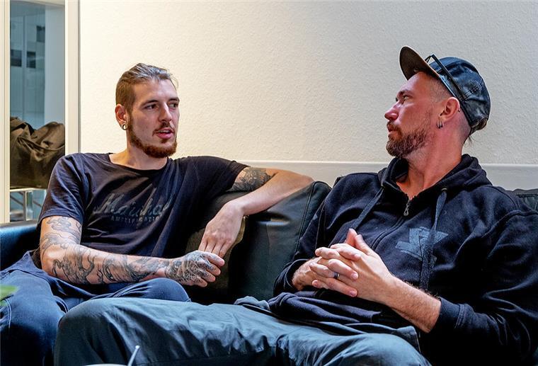 Maerzfeld: Herzensprojekt dreier Stahlzeit-Musiker zwei tätowierte Männer auf Sofa