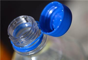 Eine Kunststoff-Wasserflasche mit geöffnetem Verschluss steht auf einem Tisch. (zu dpa: «Immer mehr winzige Plastikteilchen im menschlichen Körper»)